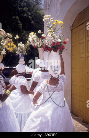 Insel Itaparica, Bahia, Brasilien. Baiana Frauen außerhalb der Kirche mit Vasen mit Blumen auf dem Kopf ganz in weiß gekleidet. Stockfoto