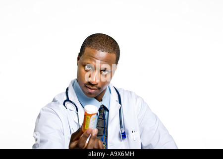 Arzt in einem weißen Kittel bieten eine Flasche von verschreibungspflichtigen Medikamenten ein Patient vor einem weißen Hintergrund. Stockfoto