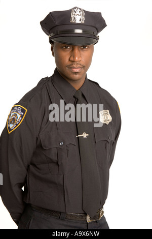 Young African American Polizist in uniform steht mit den Händen hinter seinem Rücken suchen Heck Stockfoto