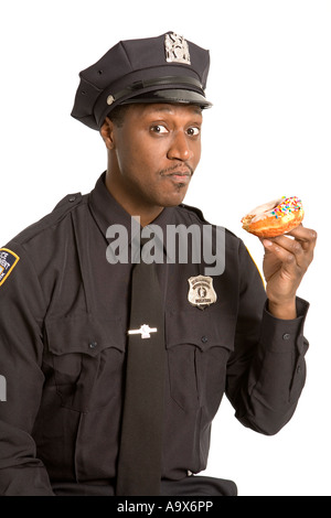 Junge schwarze Polizist Essen ein Doughnought oder Donut in Amerika in seiner uniform Stockfoto