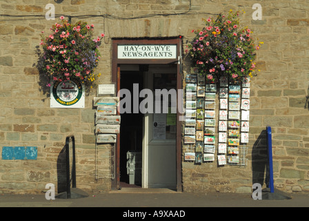 Hay on Wye kleine Marktstadt Zeitungskiosks kaufen Steinmauer façade Eingangstür Postkarten & Zeitungen in Regalen historische Grafschaft Brecknockshire Wales Stockfoto