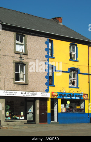 Machynlleth Ortszentrum ungewöhnliche Gebäude mit terrassenförmig angelegten Shop-Einheiten mit einer Einheit, die Hälfte ein Fensters nicht manipuliert Stockfoto