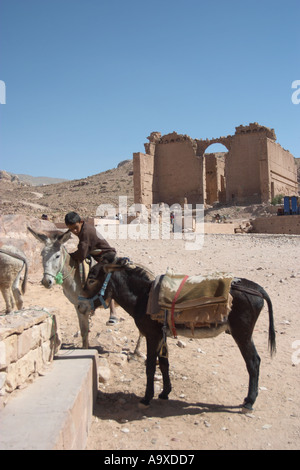 Ein Junge und seine Esel vor Qasr al-Bint, ein Tempel der Nabatäer in Petra, Jordanien. Jordanien. Stockfoto