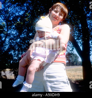Polen, Uniejow, Mutter mit Kind (3-6 Monate), stehend im Garten Stockfoto