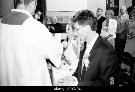 Polen, Lodz, Braut und Bräutigam kniend in Kirche, Empfang der Kommunion (B&W) Stockfoto