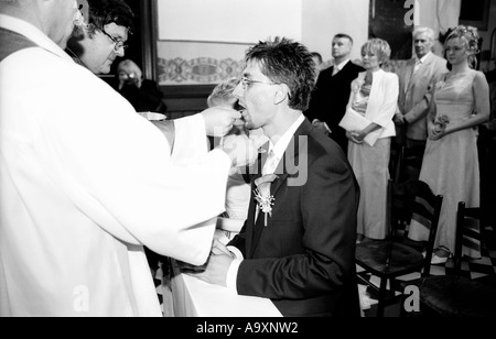 Polen, Lodz, Braut und Bräutigam kniend in Kirche, Empfang der Kommunion (B&W) Stockfoto