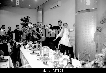 Polen, Lodz, Braut und Bräutigam mit Hochzeitsgäste Tanzen Party (B&W) Stockfoto