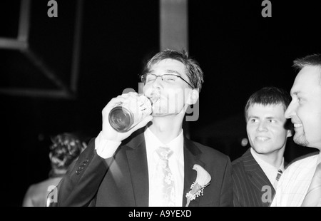 Polen, Lodz, Bräutigam und Hochzeitsgäste mit Champagner Flasche auf Hochzeitsparty (B&W) Stockfoto