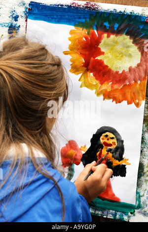 Kleines Mädchen malt eine große Blume und eine Frau, Stockfoto