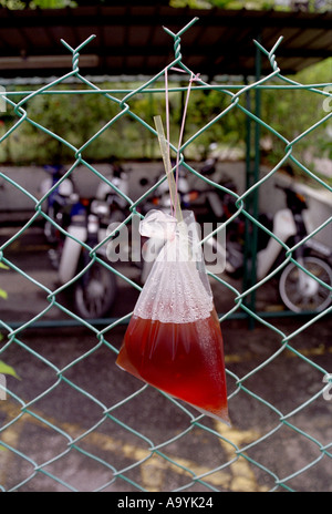 BEUTEL MIT FRUCHTSAFT HÄNGEN AN EINEM ZAUN FÜR ANYONES VERBRAUCH GEORGETOWN PENANG MALAYSIA BAPN574 Stockfoto