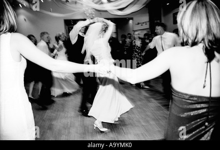 Polen, Lodz, Braut und Bräutigam tanzen mit Gästen auf Hochzeitsparty (B&W) Stockfoto