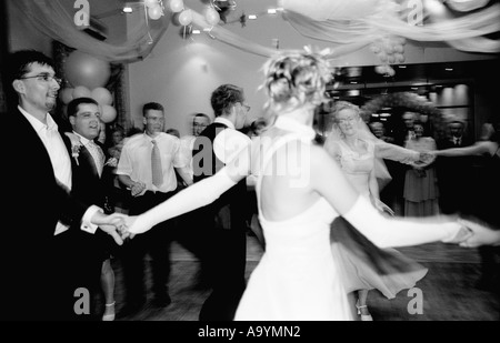 Polen, Lodz, Braut und Bräutigam tanzen mit Gästen auf Hochzeitsparty (B&W) Stockfoto