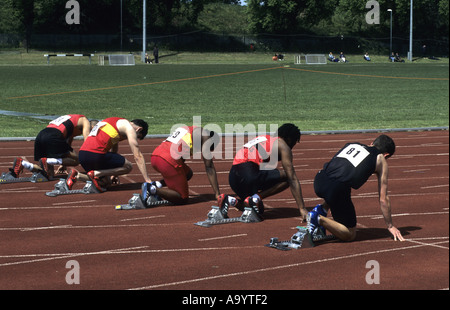 Läufer auf Ihre Marken positionieren vor 100m Rennen auf einer Leichtathletikbahn, UK Stockfoto