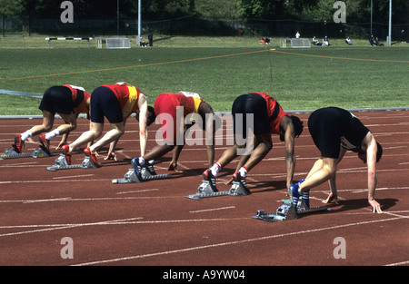 Läufer in Sollposition vor 100m Rennen auf einer Leichtathletikbahn, UK Stockfoto