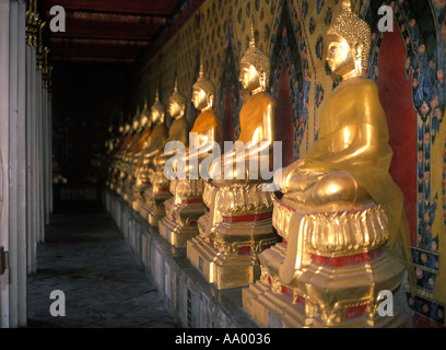 Eine Reihe von Thai gold Buddhas in eine Linie unter dem Deckmantel der beliebtes Ziel des Wat Arun oder Tempel der Morgenröte in Bangkok, Thailand Stockfoto