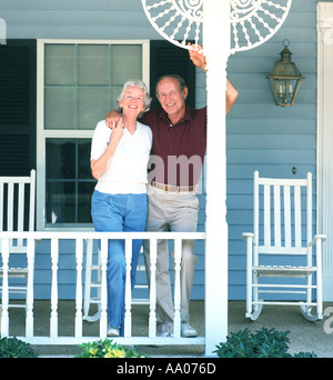 Älteres Paar halten die Hände auf der Veranda ihres Hauses Stockfoto