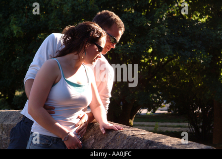 Junges Paar auf der Suche über Mauer genießen einander s Unternehmen Stockfoto