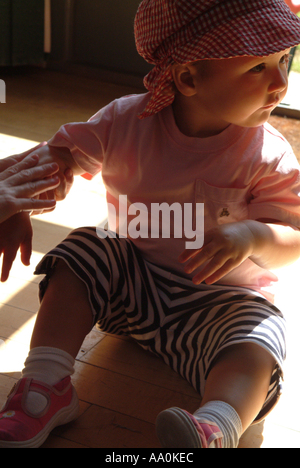 Baby mit Sonnencreme auf ihren Arm angewendet Stockfoto