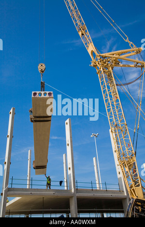 Kran heben große Betonbalken auf einer Baustelle Stockfoto