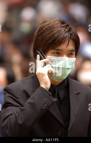 Ein Mann mit Gesichtsmaske reden auf seinem Handy während der SARS Epidemie in Hongkong 2003 Stockfoto