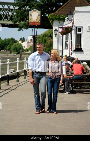 Paar am Strand auf dem Grün außerhalb der Bulls Head Pub Chiswick London Stockfoto