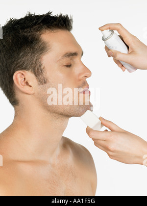 Mann mit Wasser besprüht auf seinem Gesicht Stockfoto