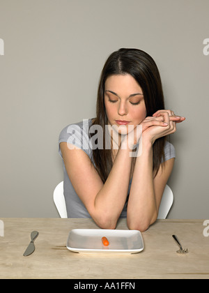 Junge Frau mit Karotte auf einem Teller Stockfoto