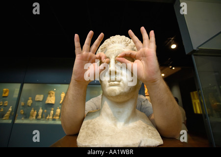 Mann, Gläser mit Händen auf Statue Stockfoto