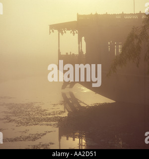 Silhouette des typischen Hausboot in nebligen Morgen Spiegelbild spiegelt sich in den Gewässern auf See Nagin Srinagar Kaschmir Indien Stockfoto