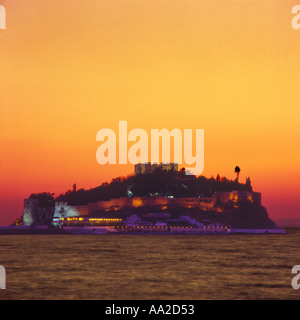 Die beleuchtete Burg Festung auf der Insel Vorgebirge von Guvercin Adasi oder Pigeon Island Silhouette bei Sonnenuntergang Kusadasi Türkei Stockfoto