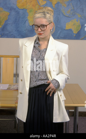 Stern Geschäftsfrau Brille trägt und weiß, zweireihiger Blazer in einem Raum oder Büro mit großen Karte der Welt hinter Stockfoto