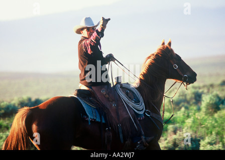 Eine funktionierende Cowboy in eine Richtung vom Pferderücken auf einer Ranch in Oregon Stockfoto