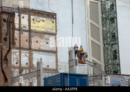 Zwei Bauarbeiter tragen Schutzhelme angehoben in beweglichen Käfig auf Baustelle, London, UK, 2006 Stockfoto