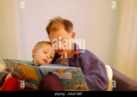 Vater liest seine wenig fünf Jahre alten Jungen ein Bilderbuch Bilderbuch Stockfoto