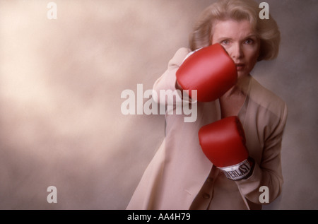 Reife Geschäftsfrau mit Boxhandschuhen Studioaufnahme Stockfoto