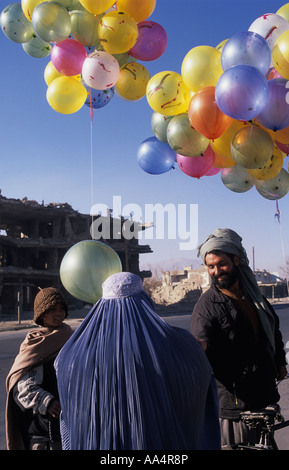 Afghanistan Kabul 2001 Mann Ballon an Frau in Burka zu verkaufen Stockfoto