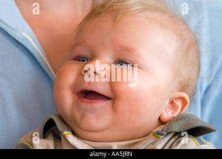 Horizontal nahe Augen Porträt eine schöne blonde Haare, blaue 6 - Monate alten Babyjungen Lachen und kichern. Stockfoto