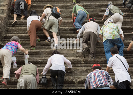 Touristen steigen die steilen Stufen an das zentrale Heiligtum des Angkor Wat Stockfoto