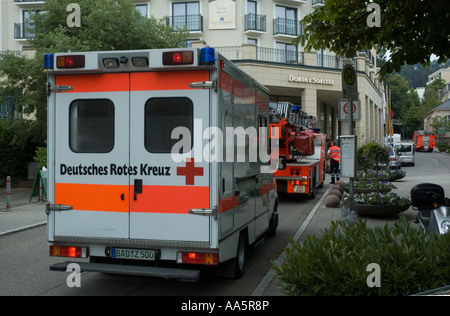 Rotes Kreuz Rettungswagen in Deutschland bei einem Aufruf, mit Fireladder im Hintergrund, Stockfoto