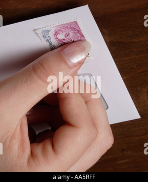 senden Sie Frau Hände Stick Kleber Briefmarke Umschlag Fingerhut Stockfoto