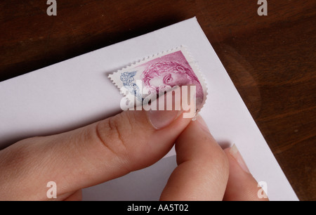 senden Sie Frau Hände Stick Kleber Briefmarke Umschlag Fingerhut Stockfoto