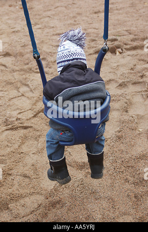 ANG104006 kleiner Junge zweieinhalb Jahren sitzen in dunklen blau Schaukel Schweden Model Release 468 Stockfoto
