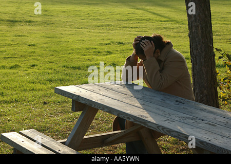 Indische ältere Frau, die den Kopf drückt, auf Bank sitzend, Schweden, Model Release 468 Stockfoto