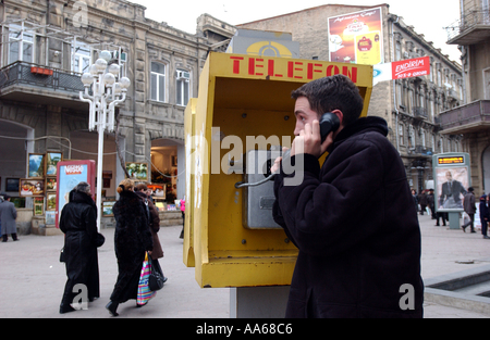Baku Aserbaidschan 11. Januar 2003 eine Azeri Teenager macht einen Anruf in der Innenstadt von Baku, wo Händler verkaufen, ihre Stockfoto