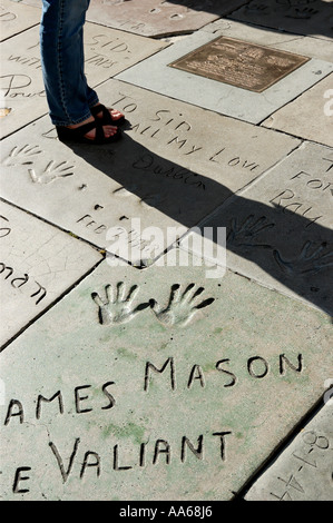 Frau, die auf Promi-Hand und Fußabdrücken auf dem Vorplatz des Manns Chinese Theatre in Hollywood, Kalifornien, USA, steht Stockfoto