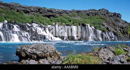 Hraunfossen Wasserfall fließt aus unter vulkanischer Lava Felsen Feld in schönen blauen Fluss namens Hvita in West-Island Stockfoto