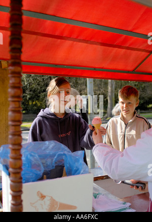 ein Junge und ein Mädchen ein Eis von einem Straßenhändler kaufen Stockfoto