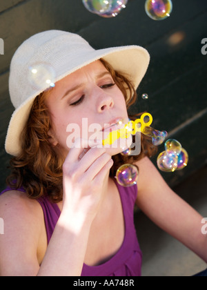 Teenager-Mädchen jungen Frau mit Sommerhut bunte Seifenblasen Stockfoto