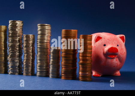 Einsparungen "Piggy Bank" mit Stapeln von Geld. Stockfoto