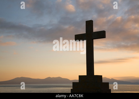 St Dwynwen Steinkreuz in der Silhouette bei Sonnenuntergang auf Llanddwyn Island in der Nähe von Newborough Isle of Anglesey North Wales UK Großbritannien Stockfoto